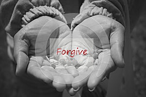 Inspirational word - forgive in an open hand in black and white background. Forgiveness and self healing concept.
