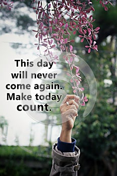 Inspirational words - This day will never come again. Make today count. Motivational quote concept with hand picking pink flower