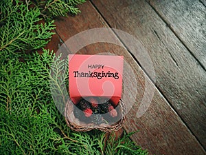 Inspirational words of happy thanksgiving written on paper with Christmas ornaments background