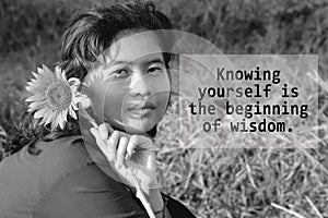 Inspirational words - Knowing yourself is the beginning of wisdom. With young woman holding sunflower in hand on black and white.