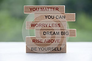 Inspirational words on wooden blocks - you matter, you can, worry less, dream big, rise above, be yourself
