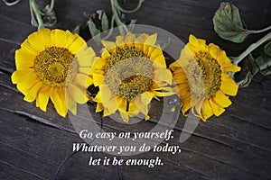 Inspirational words with yellow sun flowers - Go easy on yourself. Whatever you do today, let it be enough.