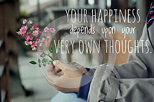 Inspirational words - Your happiness depends upon your very own thoughts. Hands holding pink little roses plant. photo