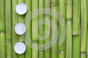 Inspirational zen background. Three candles aligned on a natural green bamboo background.