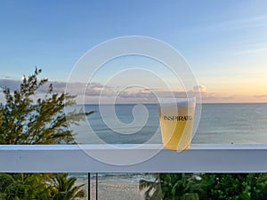 An Inspirato glass with beer overlooking the Cayman Island coast at Seven Mile Beach