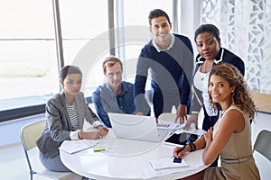 We inspire each other. Portrait of a team of smiling businesspeople working on a laptop together at a table in the