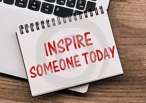 Inspire Someone Today - inscription on notepad on laptop keyboard