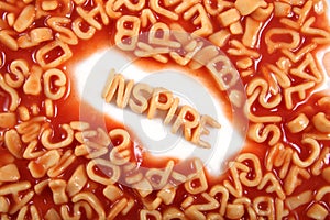 Inspire written in spaghetti pasta letters surrounded with jumbled letters photo