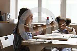 Inspired art school pupil girl drawing on canvas on class