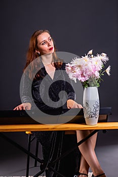 Inspired by autumn flowers, woman composes music on electronic piano photo