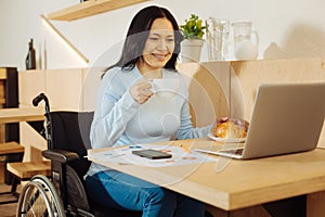 Inspired disabled woman working on her laptop