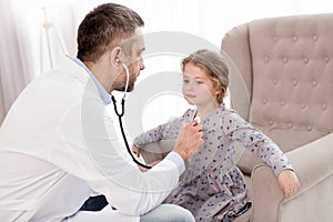 Inspired doctor listening the girls heartbeat