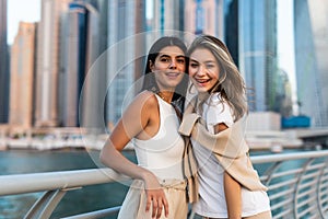 Inspired laughing ladies posing together on skycrappers background