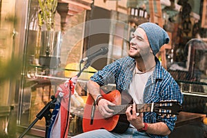 Inspired male guitarist performing song in bar