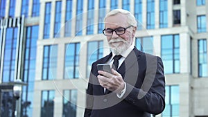 Inspired man in formal suit reading good news from stock market app for business