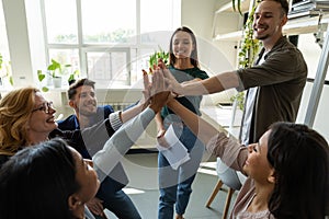 Inspired office employees giving group high five