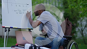 Inspired positive disabled man writing I'm the best in the world on whiteboard looking at camera and smiling. Portrait
