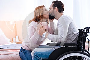 Inspired woman and paralyzed man kissing