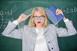 Inspiring educator spark motivation. Educator woman hold book and pen chalkboard background. Looking for inspiration