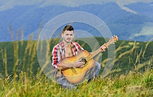 Inspiring environment. Man with guitar on top of mountain. Acoustic music. Summer music festival outdoors. Playing music