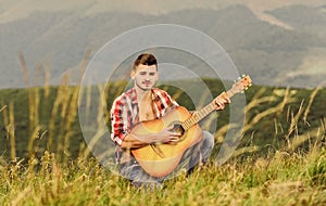 Inspiring environment. Man with guitar on top of mountain. Acoustic music. Summer music festival outdoors. Playing music