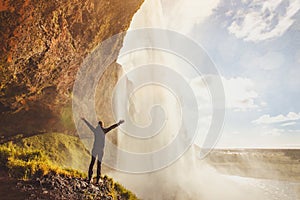 Inspiring travel landscape, person standing near beautiful waterfall