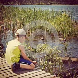 Instagram of young boy feeding ducks from his hand