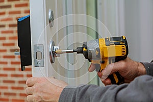 Install the door handle with a lock, Carpenter tighten the screw, using an electric drill screwdriver,