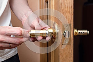 Install the door handle with a lock, man hands repair door knob, repair locking mechanism