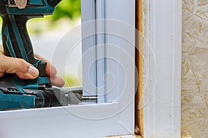 Installation and assembly of plastic window for apartment interior uses an electric drill