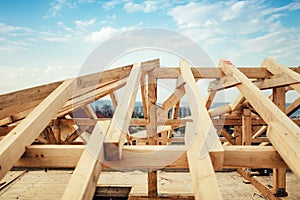 Installation of beams and timber at construction site. Building the roof truss system structure of new residential house