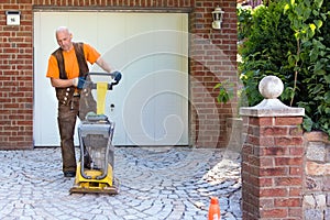 Installation of brick pavers on a driveway.