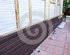 Installation of brown plastic siding on the facade