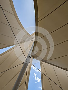 Installation of canvases on metal structures in the form of sails against a blue sky.
