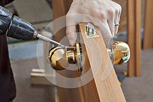 Installation door knob with lock,ÃÂ woodworker screwed screw, using screwdriver.