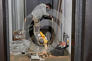 Installation of doors. The master worker installs a door lock in the door of the room