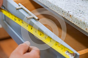 Installation of drawers handles on kitchen cabinets