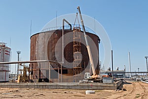 Repair work on replacement of lower belts of old rusty tank for