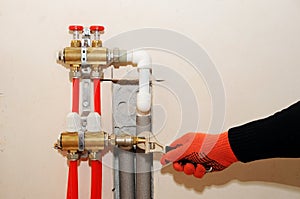 Installation individual of home heating. A plumber attaches the tube to the collector heating. Underfloor heating installation. photo