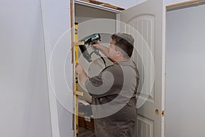 During the installation of interior doors in a new house, a trim carpenter installs the doors