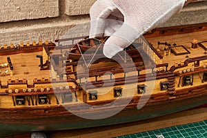 Installation of lifeboats on the ship model. Assembly of ship model from wood