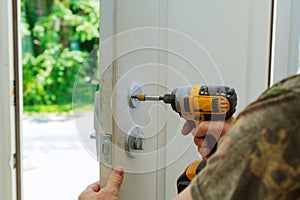 Installation locked interior door knobs, close-up woodworker hands install lock.