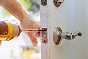 Installation locked interior door knobs, close-up woodworker hands install lock.