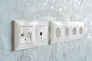 Installation of modern power, communication LAN RJ45 and television sockets on a wall close-up.