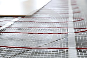 Installation of modern underfloor trace heating system indoors, closeup