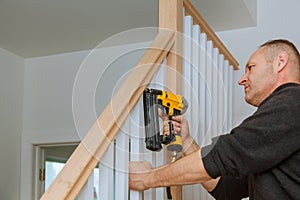 Installation nailing the railing for stairs with an air gun wooden railing