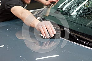 Installation of a protective paint and varnish transparent film on the car. PPF polyurethane film to protect the car paint from