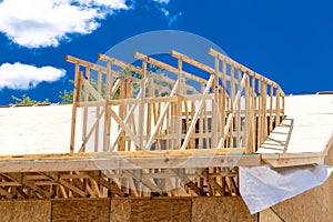 Installation of rafters on the roof of a house under construction against the background of the sky