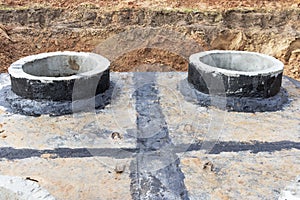 Installation of a reinforced concrete well for water supply and sewerage at the construction site. Well rings with cast iron hatch