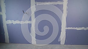 Installation or renovation of plasterboard partitions in a house. Blue drywall on the wall in a new apartment.